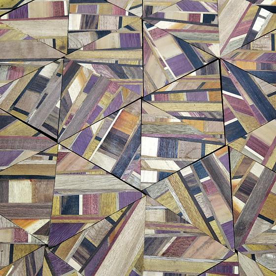 Marchetaria em triângulos de madeiras de várias cores.
