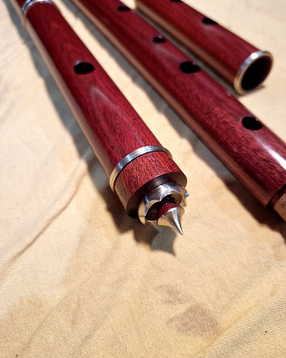Corpos de flauta avermelhados, com anéis de latão e coroa com ponteira.