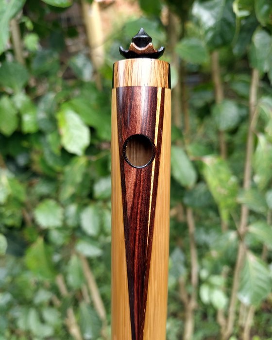 Quatro pífanos de bambu na grama.