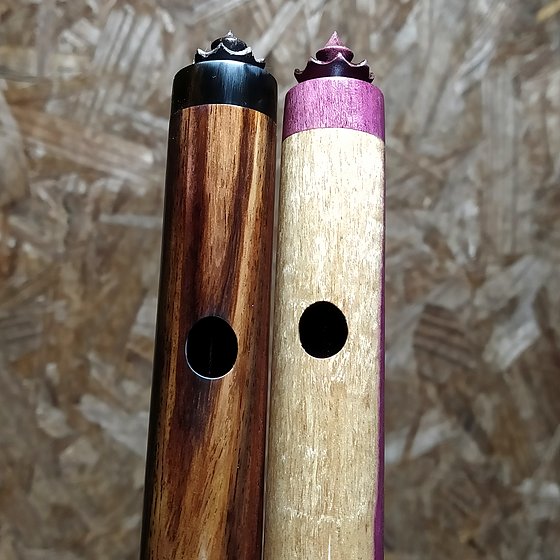 Duas flautas de madeiras diferentes, com coroa.