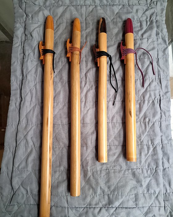 Quatro flautas nativas de bambu lado a lado.